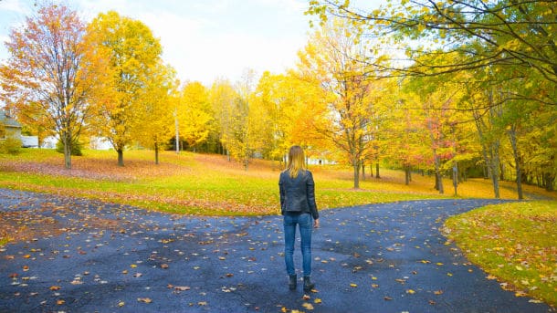 Woman deciding which path to take at a fork in the road